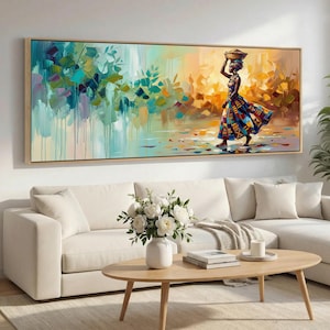 May include: An abstract painting on canvas depicts a woman carrying a basket on her head, walking in a colorful landscape. The artwork features a wooden frame and a vibrant color palette of blues, greens, and oranges.