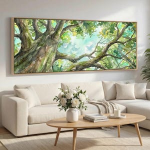 May include: A watercolor painting of a tree canopy in a light wood frame. The artwork features a detailed depiction of tree branches and green leaves, with a light blue sky peeking through. The painting is displayed above a white sofa and wooden coffee table.