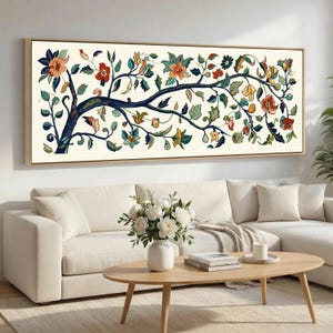 May include: A rectangular framed canvas art piece featuring a stylized tree with colorful flowers and leaves. The artwork has a cream-colored background and a wooden frame. The tree's branches are dark blue, and the flowers are orange, red, and yellow.