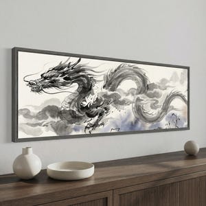 May include: A horizontal rectangular wall art piece featuring a black ink wash painting of a long, serpentine dragon winding through swirling clouds. The artwork is enclosed in a dark gray frame, showcasing expressive brushstrokes and shading.