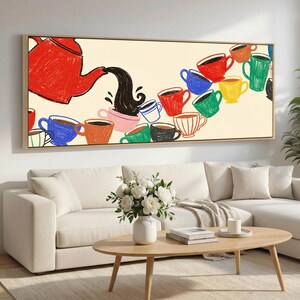 Op de afbeelding: Een ingelijste canvas kunstdruk toont een rode theepot die donkere vloeistof in een reeks kleurrijke koffiekopjes giet. De kopjes zijn in verschillende kleuren, waaronder rood, blauw, groen en geel, tegen een crèmekleurige achtergrond. Het kunstwerk heeft een grillige, illustratieve stijl.