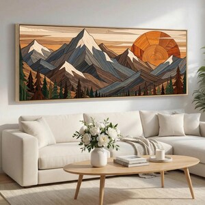 May include: A rectangular wall art piece featuring a layered wood mountain landscape. The scene depicts snow-capped peaks in shades of brown, gray, and white, with a large circular orange sun and a dense forest of green and brown pine trees below.