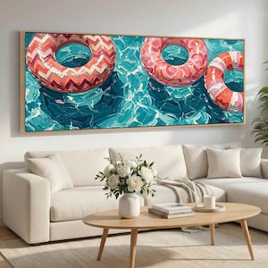 May include: A rectangular wall art piece featuring an oil painting of three inflatable pool rings floating on textured blue water. The rings are colored in shades of pink, orange, and white with chevron and striped patterns, rendered in thick brushstrokes.