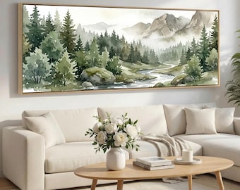 May include: A framed watercolor landscape painting depicting a forest scene with a river winding through it. The artwork features shades of green, gray, and brown, with mountains in the background. The frame is a light brown color.