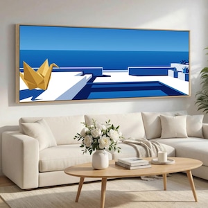 Può includere: Una stampa artistica incorniciata con un'illustrazione minimalista di una piscina e una scena oceanica nei toni del blu e del bianco, con una gru origami dorata in primo piano. L'opera è esposta sopra un divano bianco e un tavolino in legno.