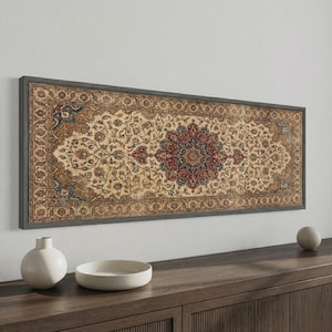 May include: A framed wall art piece with a detailed rug design. The rug features a cream background with intricate floral patterns in red, blue, and gold. The frame is a dark grey colour, creating a classic, vintage aesthetic.