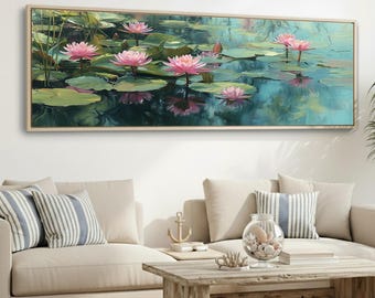 May include: Oil painting of pink water lilies floating on a pond, framed in a light wood. The artwork depicts the flowers with green lily pads and reflections in the water. The painting is displayed above a beige sofa with striped pillows.