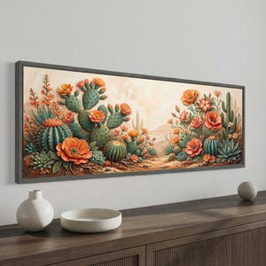 Może przedstawiać: Oprawiony wydruk na płótnie przedstawiający pustynny krajobraz z kaktusami i pomarańczowymi kwiatami. Grafika ma neutralne tło i ciemnoszarą ramę. Kaktusy są w różnych odcieniach zieleni, a kwiaty są żywo pomarańczowe.