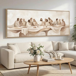 May include: A large, rectangular canvas art print depicting the Last Supper in muted beige and brown tones. The artwork features figures seated at a long table, with a neutral-toned frame. The scene is set in a living room with a white sofa and wooden coffee table.