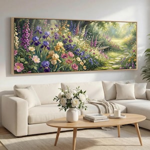 Op de afbeelding: Een groot rechthoekig ingelijst canvas kunstwerk dat een levendige tuinscène uitbeeldt. Het kunstwerk toont een verscheidenheid aan kleurrijke bloemen, waaronder irissen, vingerhoeden en rozen, met een pad dat naar een bank leidt. Het kleurenpalet omvat tinten paars, roze, geel en groen.