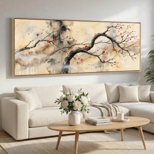 May include: A framed watercolor painting of a tree with dark branches and red blossoms. The background has a beige and brown wash with darker areas. The artwork is displayed above a white sofa and a wooden coffee table.