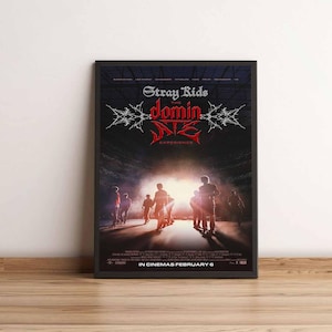 May include: Framed poster for "Stray Kids: The Dominant Experience" in a black frame. The poster features a dark background with silhouetted figures walking towards a bright light. The title is in a stylized font.