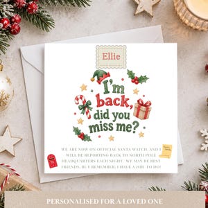 May include: A square white greeting card featuring the name Ellie at the top, followed by the text I'm back, did you miss me? surrounded by illustrations of an elf hat, candy cane, gift, and holly. Below is text about Santa watch.