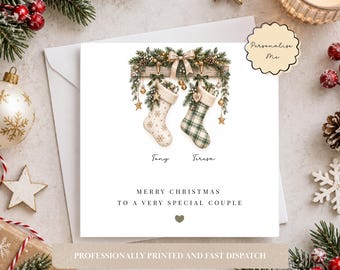 Puede incluir: Una tarjeta de felicitación cuadrada con dos calcetines navideños colgantes decorados con ramas de pino y un lazo. Un calcetín tiene un patrón de copos de nieve y el otro un estampado de cuadros verdes. Debajo, los nombres Tony y Teresa y el texto MERRY CHRISTMAS TO A VERY SPECIAL COUPLE.