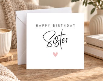 May include: A square white greeting card with a matching envelope. The card features the text "HAPPY BIRTHDAY" in a simple sans-serif font, followed by the word "Sister" in a black cursive script, and a small light pink heart below.