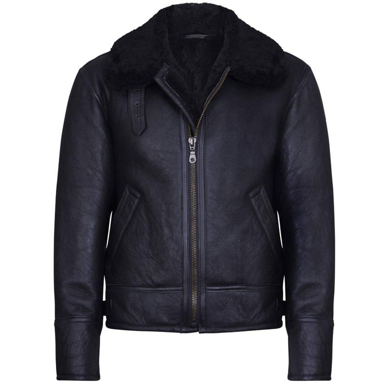 May include: A black leather jacket with a shearling collar. The jacket features a front zipper closure, two side pockets, and a buckled strap detail on the left shoulder. The sleeves have a cuff detail. The jacket is a classic outerwear piece.