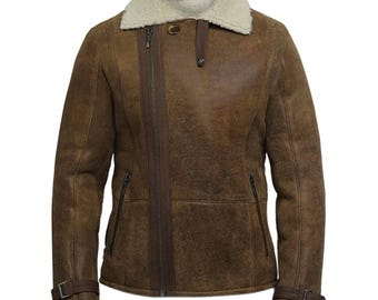 May include: Brown leather jacket with a cream-colored shearling collar. The jacket features a diagonal zipper, two side pockets, and adjustable cuffs with buckles. The jacket has a classic, rugged style.