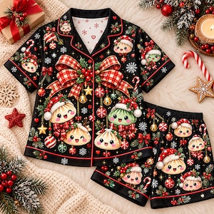 May include: A black short-sleeve pajama set featuring a festive print of smiling dumplings wearing Santa hats, red plaid bows, Christmas ornaments, candy canes, and snowflakes. The button-down shirt has a notched collar and red piping.