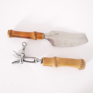May include: Two kitchen utensils with bamboo handles. The first is a silver spatula with a bamboo handle. The second is a silver ice cream scoop with a bamboo handle.