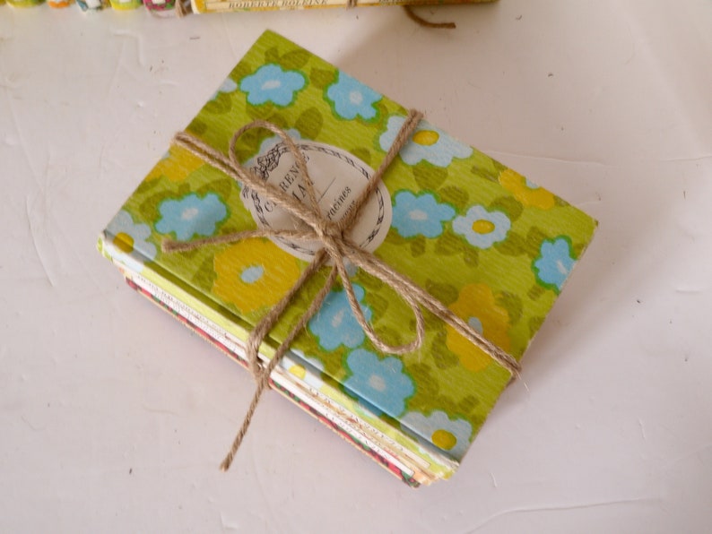 Puede incluir: Una pila de peque&ntilde;os diarios vintage con estampado floral, atados con cuerda. El diario de arriba tiene una etiqueta que dice "RENDEZVOUS JOURNAL" con una fecha manuscrita de "Oct 1968".