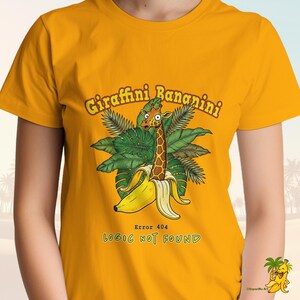 Puede incluir: Camiseta amarilla mostaza con una jirafa de dibujos animados saliendo de una cáscara de plátano, con el texto "Giraffini Bananini" arriba y "Error 404 Logic Not Found" abajo. El diseño incluye hojas tropicales.