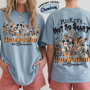 May include: A light blue t-shirt featuring a graphic of Disney characters in skeleton costumes. The front and back display the text Mickey's Not So Scary Halloween Party Walt Disney World. The shirt is labeled Comfort Colors Chambray.