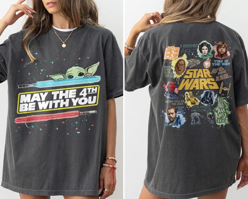 May include: Dark gray t-shirt featuring a graphic of Baby Yoda, lightsabers, and the text "MAY THE 4TH BE WITH YOU." The back of the shirt displays various Star Wars characters and the words "STAR WARS."