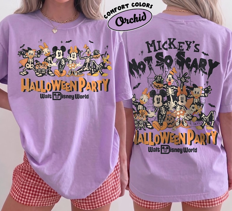May include: A light purple t-shirt featuring a graphic of Disney characters in skeleton costumes. The front and back display the text Mickey's Not So Scary Halloween Party Walt Disney World with illustrations of Mickey, Minnie, Donald, and Goofy.