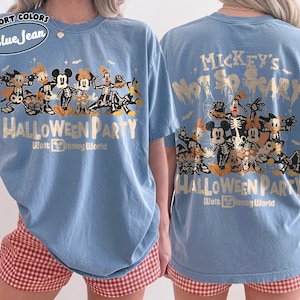 May include: A blue short-sleeve t-shirt featuring a graphic of Disney characters in skeleton costumes. The text reads Mickey's Not So Scary Halloween Party Walt Disney World. The design includes Mickey, Minnie, Donald, Daisy, Goofy, Pluto, and Chip 'n Dale.