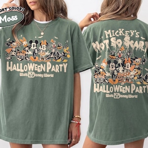 May include: A moss green t-shirt featuring a graphic of Disney characters in skeleton costumes. The front displays the text Mickey's Not So Scary Halloween Party Walt Disney World. The back shows a larger version of the same graphic and text.
