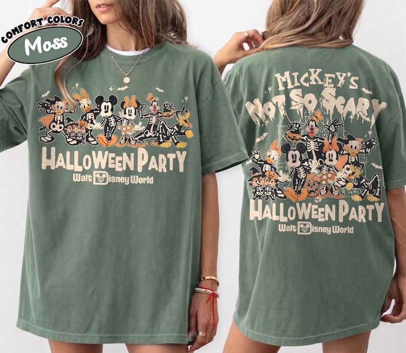 May include: A moss green t-shirt featuring a graphic of Disney characters in skeleton costumes. The front displays the text Mickey's Not So Scary Halloween Party Walt Disney World. The back shows a larger version of the same graphic and text.