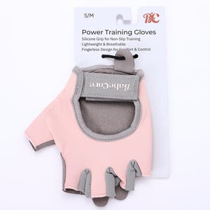 以下が含まれることがあります： ピンクとグレーの指なしパワートレーニンググローブ、サイズS/M、手首ストラップにブランド名「BabeCore」入り。滑り止めトレーニング用に設計されており、軽量で通気性があります。