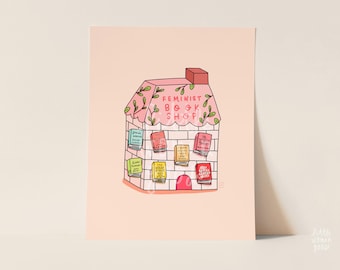 May include: A rectangular art print on a light peach background featuring a hand-drawn illustration of a brick building labeled Feminist Book Shop. The building has a pink roof with green leaves and several colorful books displayed on the facade.