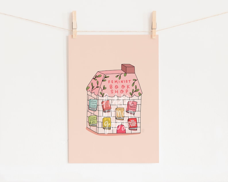 May include: A pink illustration of a house with a sign that reads "Feminist Book Shop". The house is decorated with green vines and has books stacked on the outside.