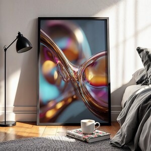 Peut inclure: Impression d'art abstrait encadrée en noir. L'œuvre présente un design fluide et irisé avec des teintes dorées, orangées et bleues. Un lampadaire noir et une tasse de café sur un livre floral sont au premier plan.
