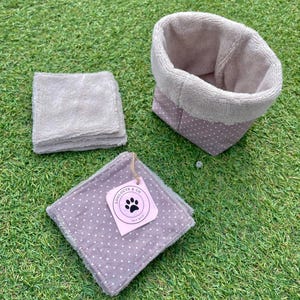 Peut inclure: Un ensemble de lingettes grises, un panier assorti et un carré de tissu à pois blancs. Le carré de tissu porte une étiquette avec l'inscription "Louloute & Co", un logo de patte et les mots "Face Wash".