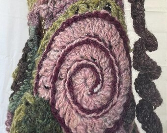 May include: A crocheted shawl with a pink and purple spiral design, green and brown accents, and a brown crocheted border.