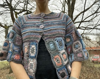 May include: A crocheted cardigan with a striped pattern and a granny square design. The cardigan is open in the front and has a button closure.