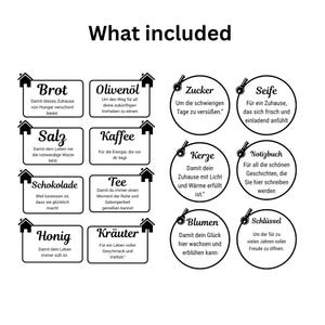 May include: A black and white graphic titled What included featuring eight rectangular labels with house icons and six circular labels with key icons. Each label contains German text describing symbolic gifts like bread, oil, salt, coffee, chocolate, tea, honey, herbs, sugar, soap, candles, notebooks, flowers, and keys.
