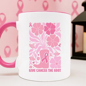 May include: A white ceramic mug with a black handle and the text "But First, Coffee" in a bold, black font. The mug is filled with a dark liquid, likely coffee, and sits on a light-colored surface.