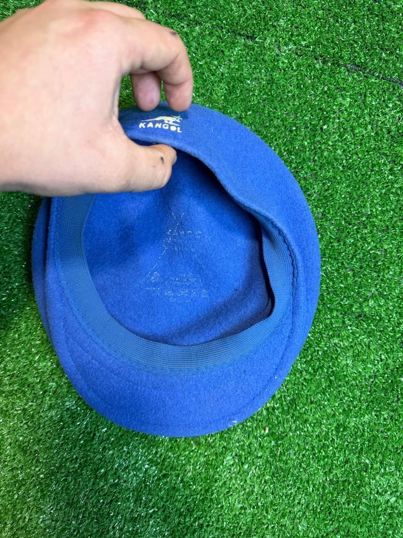 K&ouml;nnte beinhalten: Ein blauer Kangol-Barett. Der Hut besteht aus einem weichen Material und tr&auml;gt das Kangol-Logo. Der Barett ist ein klassischer Stil und hat eine einfarbige blaue Farbe.