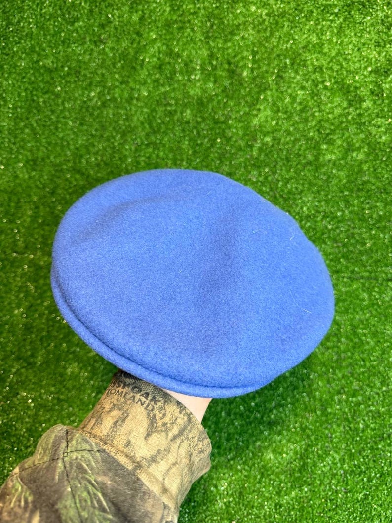 K&ouml;nnte beinhalten: Ein einfarbiger blauer Barett-Hut. Der Hut besteht aus einem weichen, filzartigen Material. Der Hut ist ein klassischer Stil, der f&uuml;r verschiedene Anl&auml;sse geeignet ist. Der Hut hat einen leuchtenden Blauton.