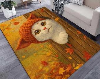 May include: A rectangular rug featuring a whimsical illustration of a white cat wearing an orange hat, set against a backdrop of autumn leaves. The rug has a wooden fence design and is bordered by a yellow and orange gradient.