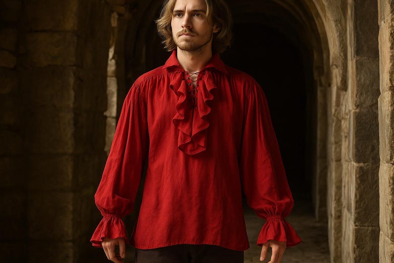 May include: A red long-sleeve shirt with a ruffled front and cuffs. The shirt has a lace-up neckline and is made of a soft fabric. The sleeves are long and gathered at the wrists. The shirt is a historical or renaissance style.