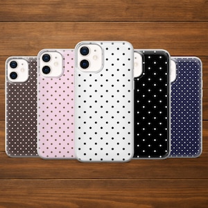 May include: Five phone cases with a polka dot pattern in various colours: brown, pink, white, black, and navy blue. The cases are made of a clear material with a polka dot design.
