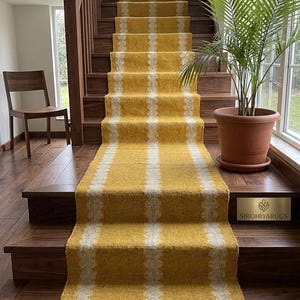 May include: A stair runner with a yellow and white checkered pattern, installed on wooden stairs. The runner has a fringed edge and is paired with a wooden banister and a potted plant. The brand name "SIROHIYARUGS" is visible.