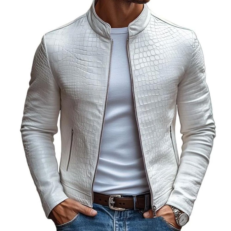 Pode incluir: Casaco de couro branco texturizado com padr&atilde;o de pele de crocodilo. O casaco tem gola alta, z&iacute;per frontal e dois bolsos laterais. O modelo veste uma camiseta branca e jeans azul.