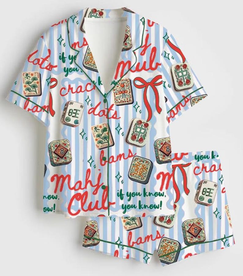 Peut inclure: Un ensemble pyjama compos&eacute; d'une chemise &agrave; manches courtes boutonn&eacute;e et d'un short assorti, avec un motif &agrave; rayures verticales bleu clair et blanc. Le tissu est orn&eacute; d'illustrations de tuiles de mah-jong, de rubans rouges et du texte Mahj Club.