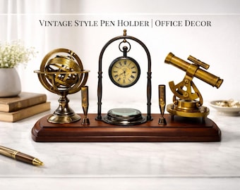 May include: A desk organizer on a dark wood base featuring a brass armillary sphere, a hanging pocket watch with a compass base, and a small brass telescope. The text VINTAGE STYLE PEN HOLDER | OFFICE DECOR is displayed above the objects.