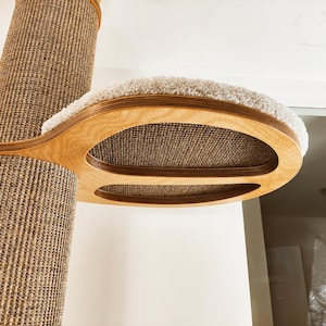 Può includere: Un albero per gatti con un palo rivestito in sisal e una piattaforma in legno. La piattaforma ha un letto morbido e felpato e una superficie antigraffio in sisal intrecciato. L'albero per gatti è progettato per arrampicarsi e graffiare.